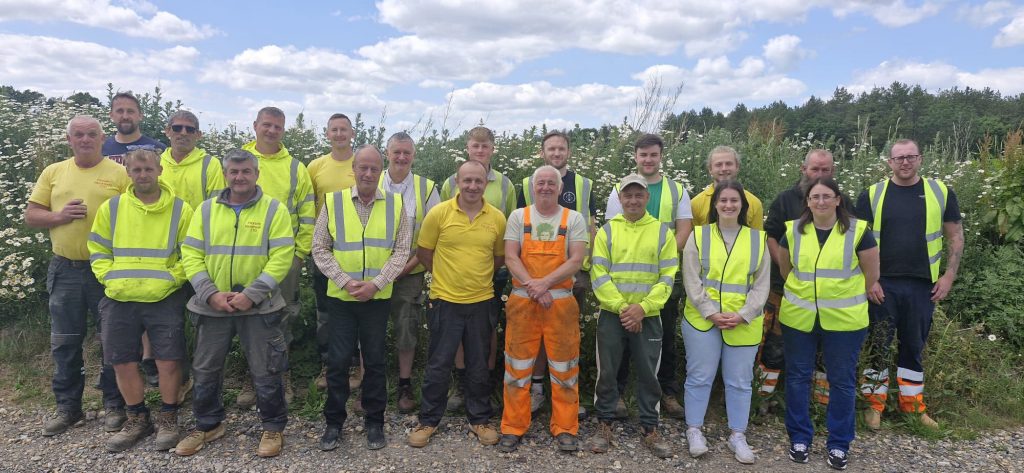 Staff members of Playsafe Playgrounds standing together in the company yard